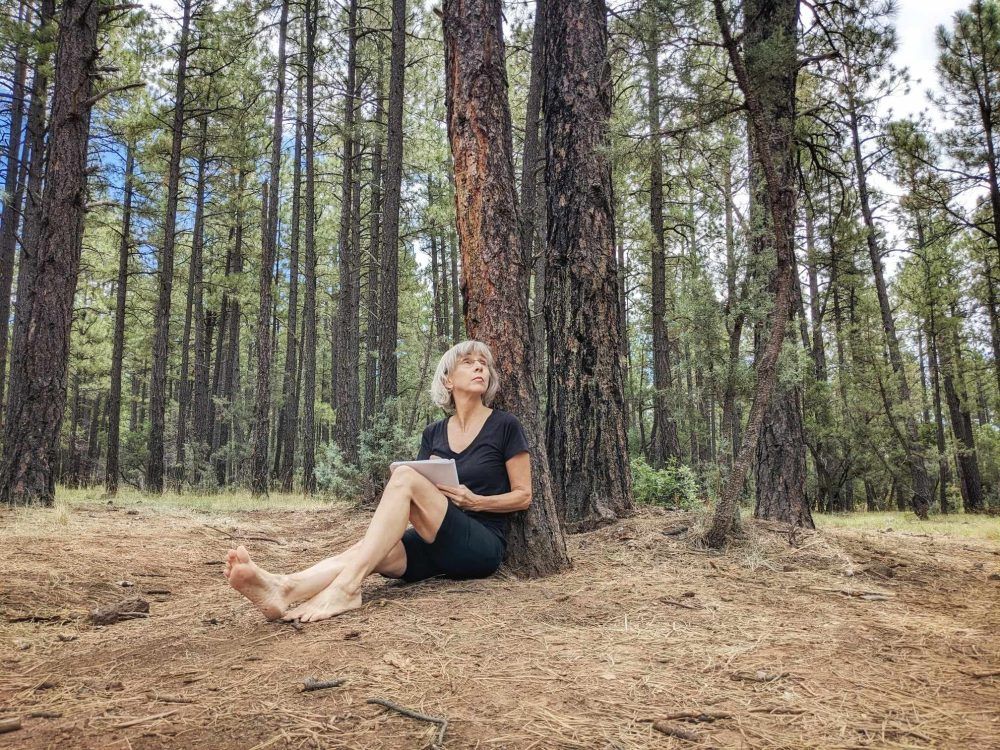 Lorraine Haataia Journaling in a pine forest - Writer's MInd